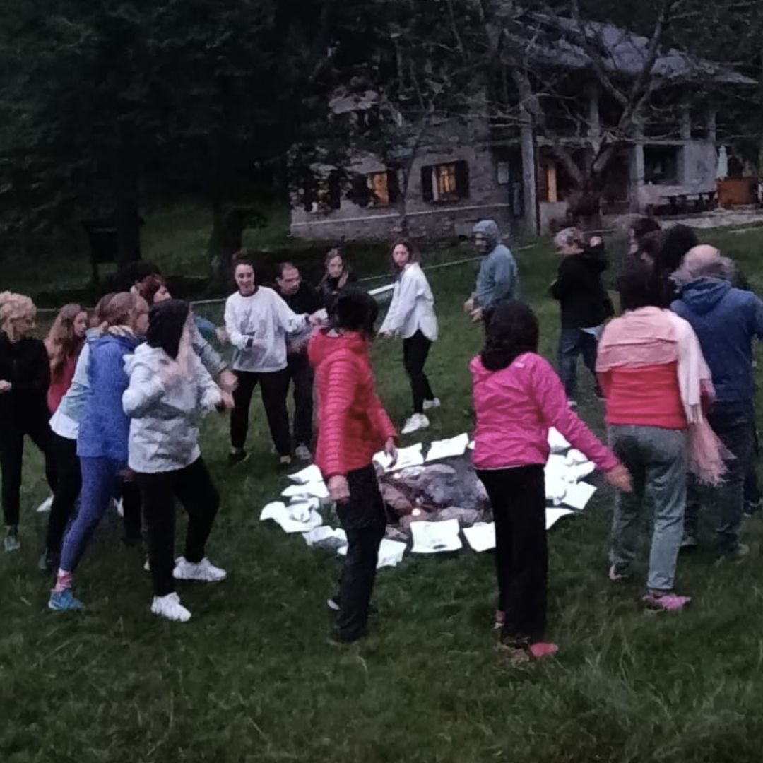 Il gruppo in cerchio durante un rituale all'aperto