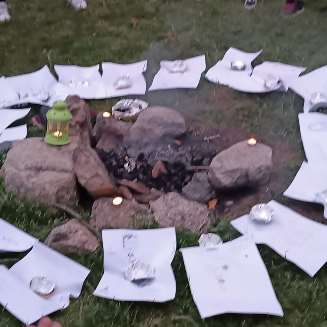 Cerchio rituale intorno al fuoco con candele e disegni