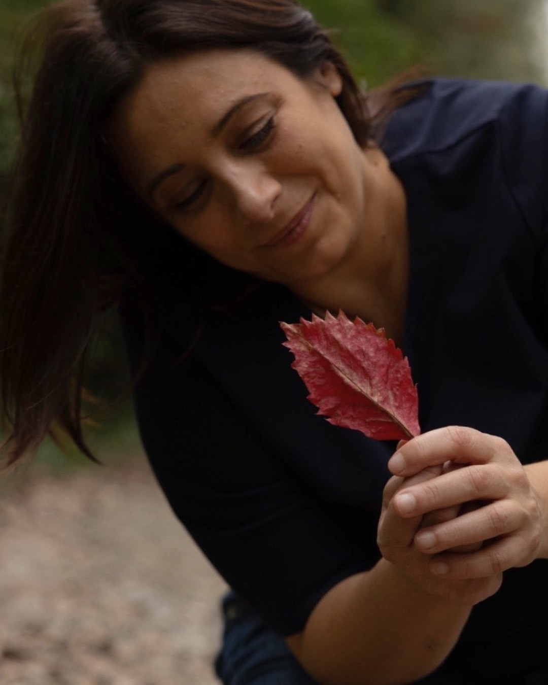 Valeria Curzio osserva una foglia d'autunno rossa tra le mani